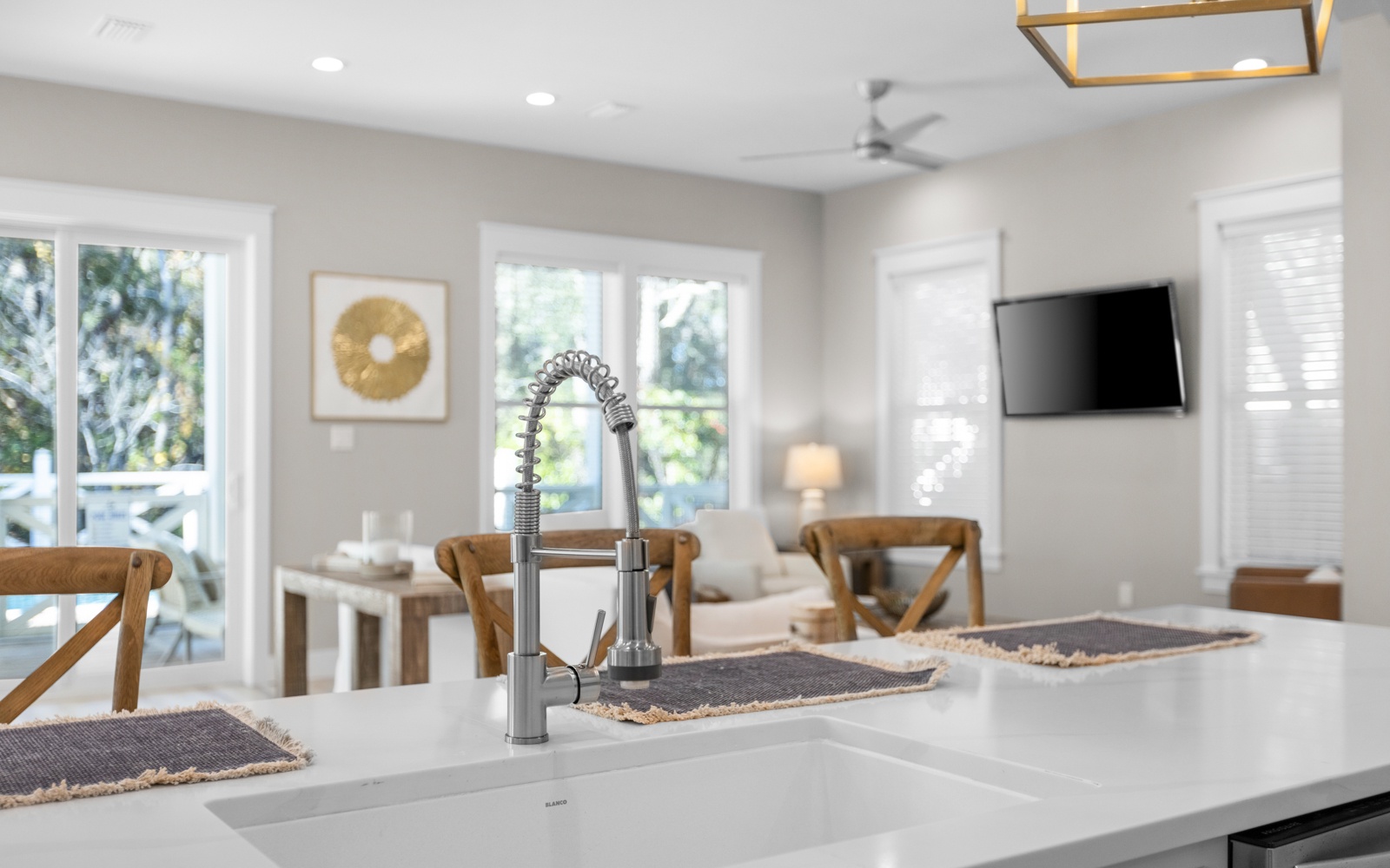 Your modern kitchen island flows seamlessly into a bright living space, where warm wood accents and natural light create the perfect gathering spot for your getaway.