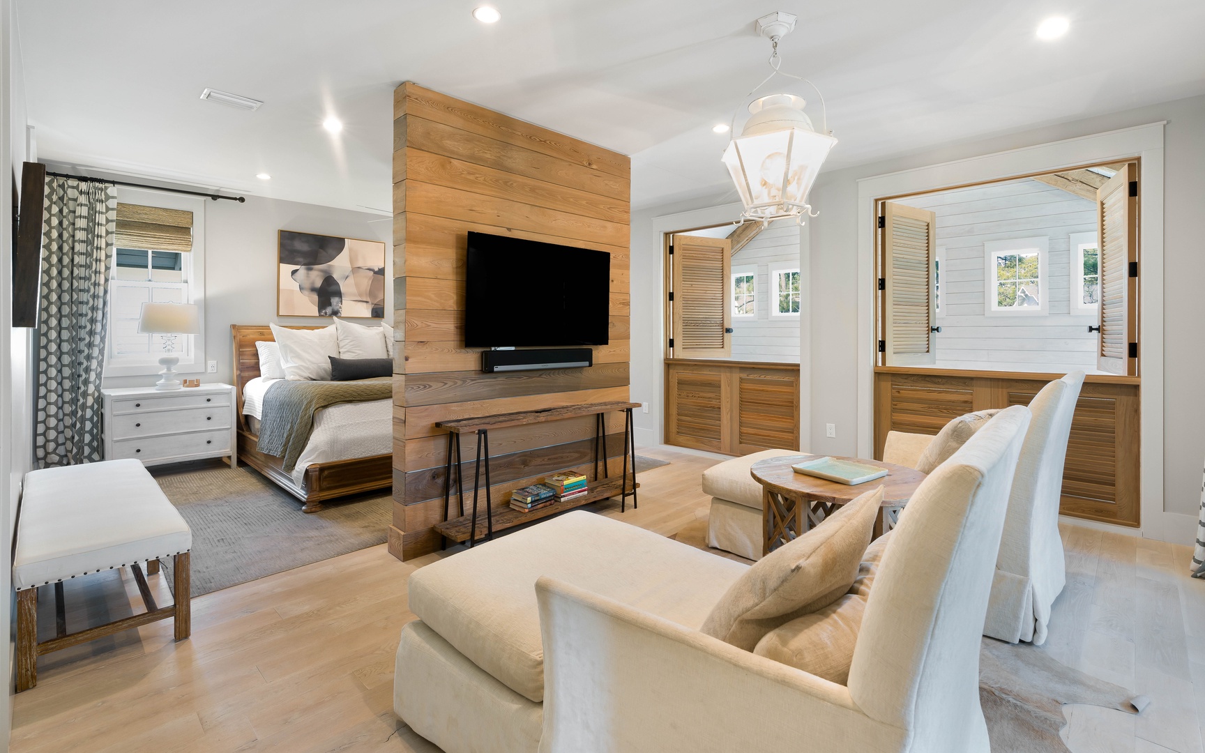 Relax in your sophisticated suite where warm wood meets modern comfort—plush seating, entertainment center, and elegant touches create your perfect retreat.