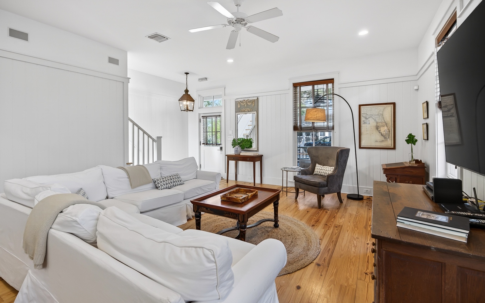 Sink into plush white sofas in your bright living room, where warm wood floors and cozy reading nooks create the perfect retreat.