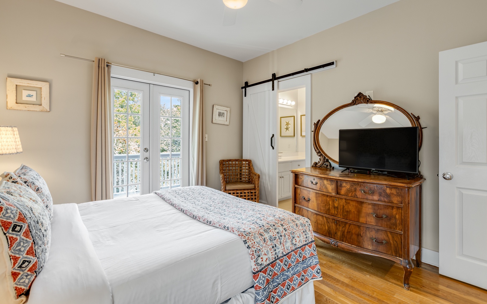 Sink into crisp linens and watch your favorite shows in this charming bedroom, complete with antique furnishings and peaceful balcony doors.