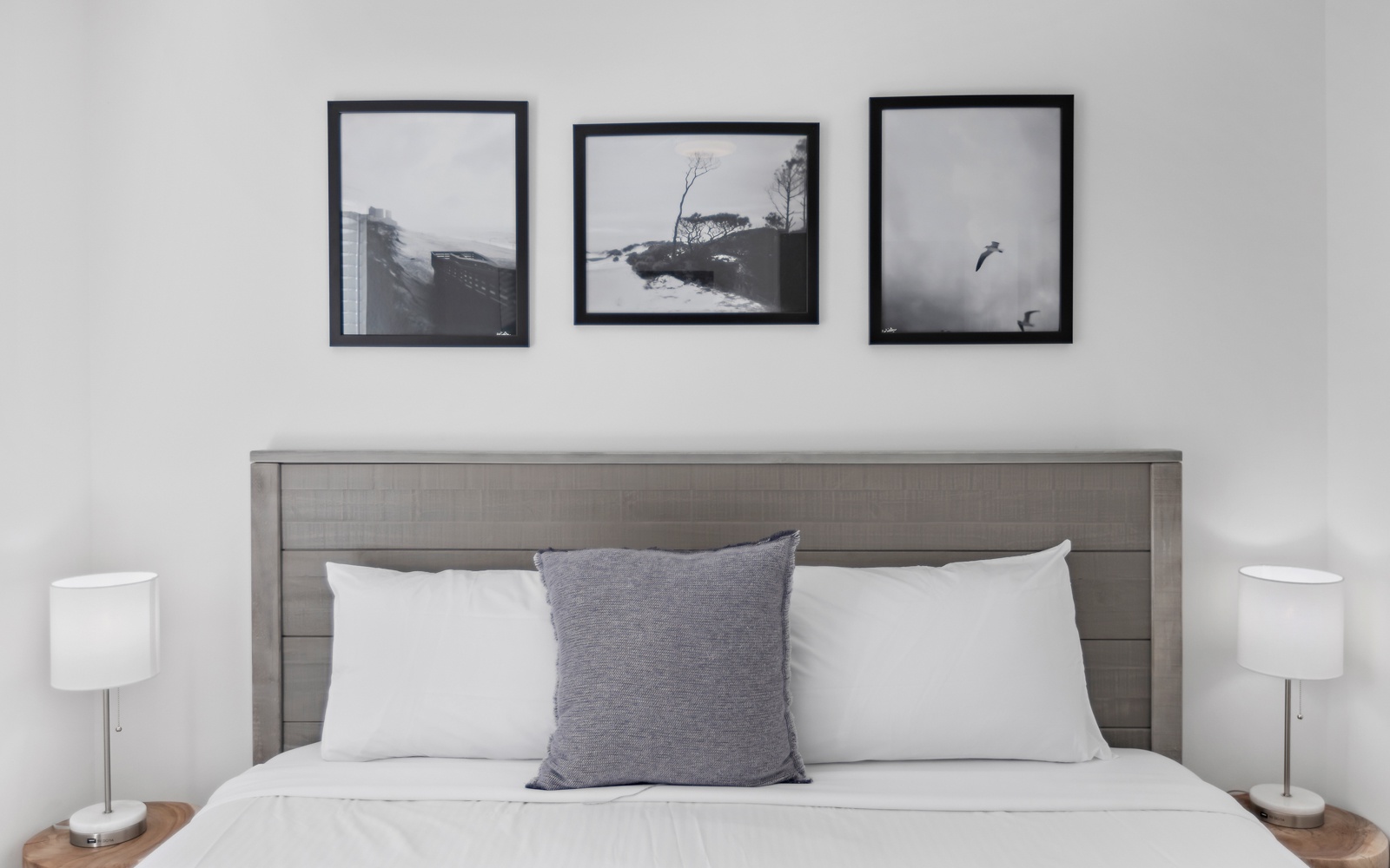 Sink into crisp white linens beneath calming monochrome artwork that creates your peaceful retreat for restful nights.