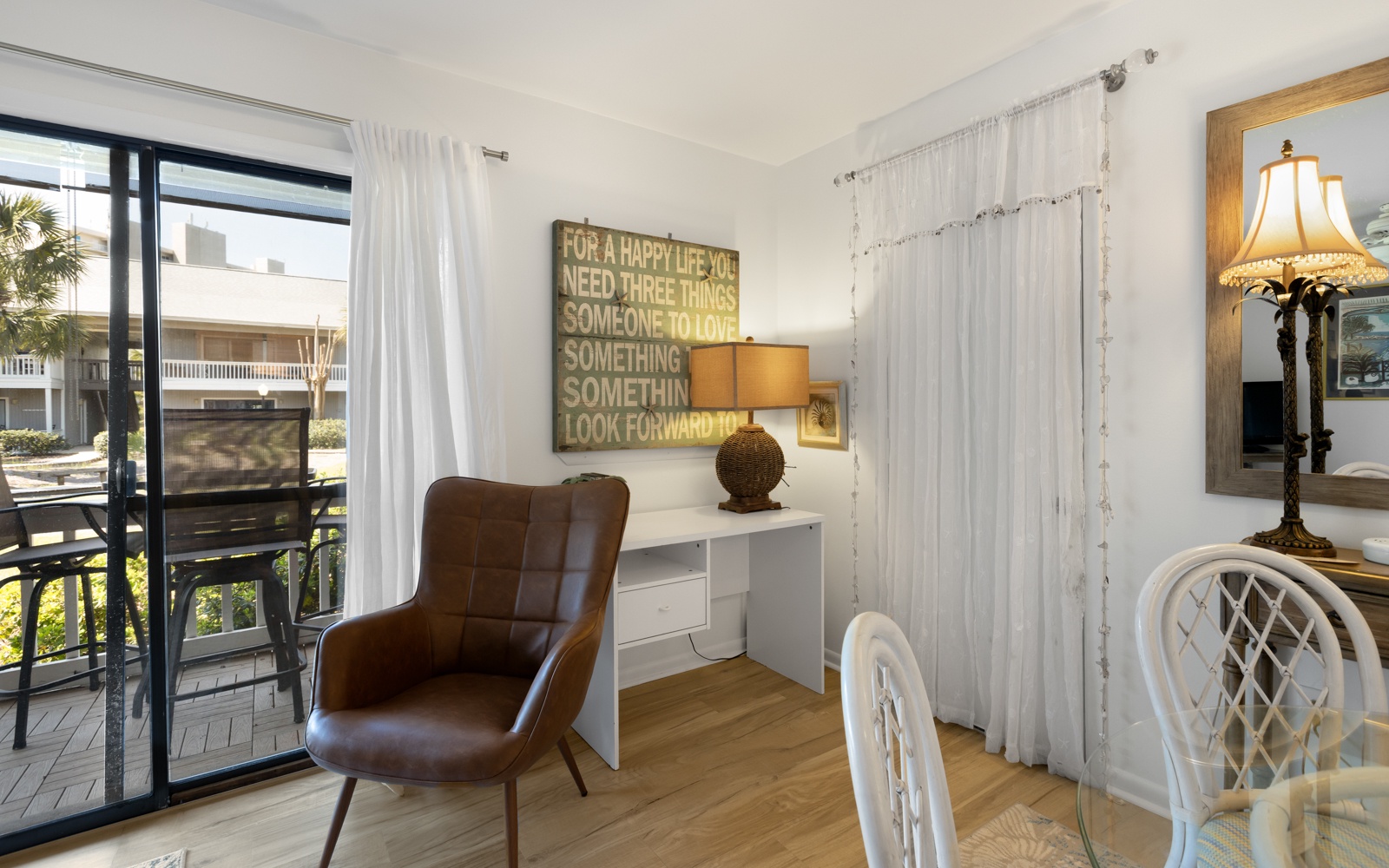 Settle into your bright workspace where inspirational art meets modern comfort, perfectly positioned by windows overlooking tropical palms.