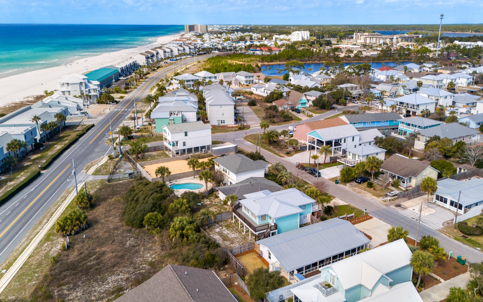 Coastal neighborhood featuring beach houses and vacation rentals just steps from pristine white sand beaches and turquoise waters.