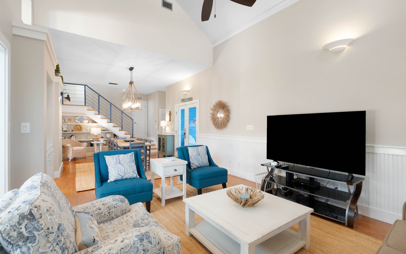 Relax in your stylish living room with vaulted ceilings, cozy blue chairs, and entertainment center for perfect evenings in.