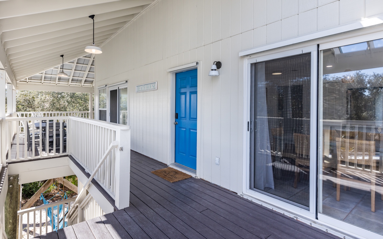 Step onto your private covered balcony and feel instantly at home with the cheerful blue door welcoming you to your coastal retreat.