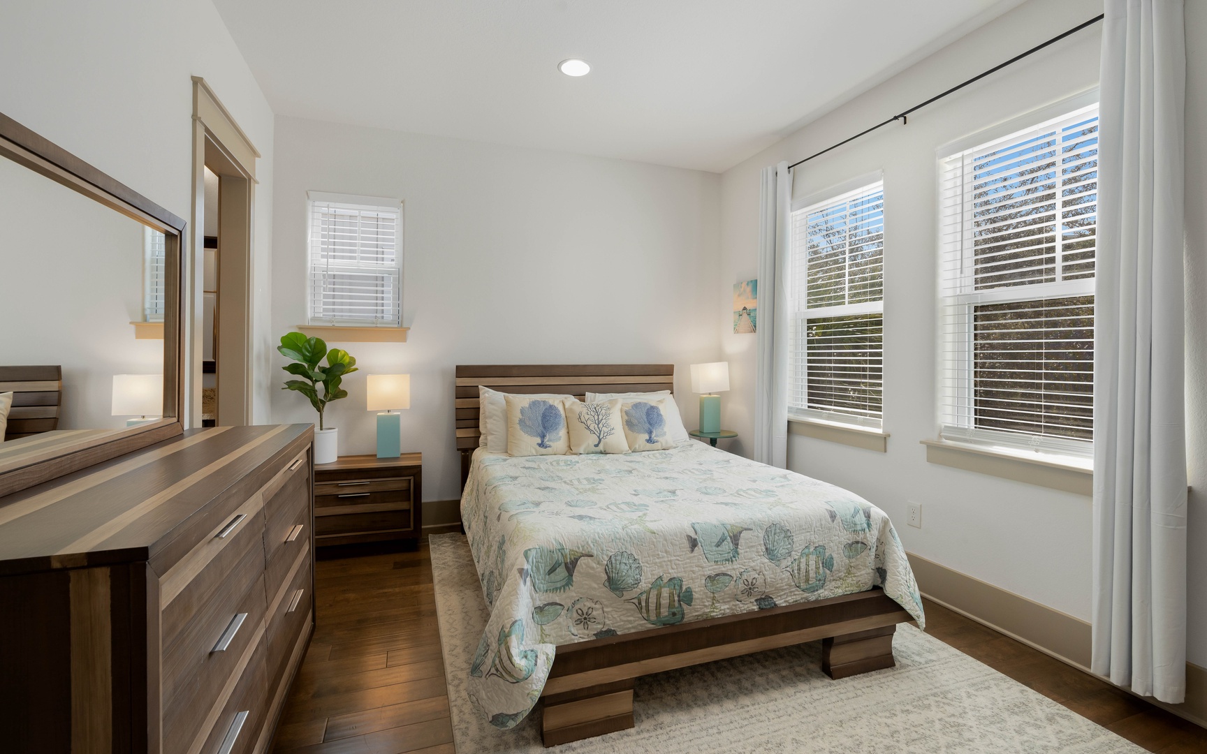 Drift into peaceful sleep in your serene bedroom, where ocean-themed linens and warm wood tones create the perfect coastal retreat.