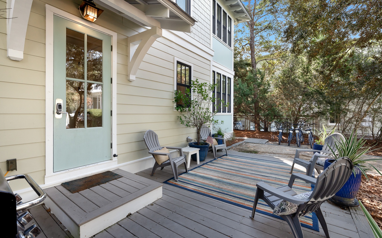 Charming entrance with coastal-style porch featuring comfortable seating where you can sip morning coffee surrounded by lush greenery.