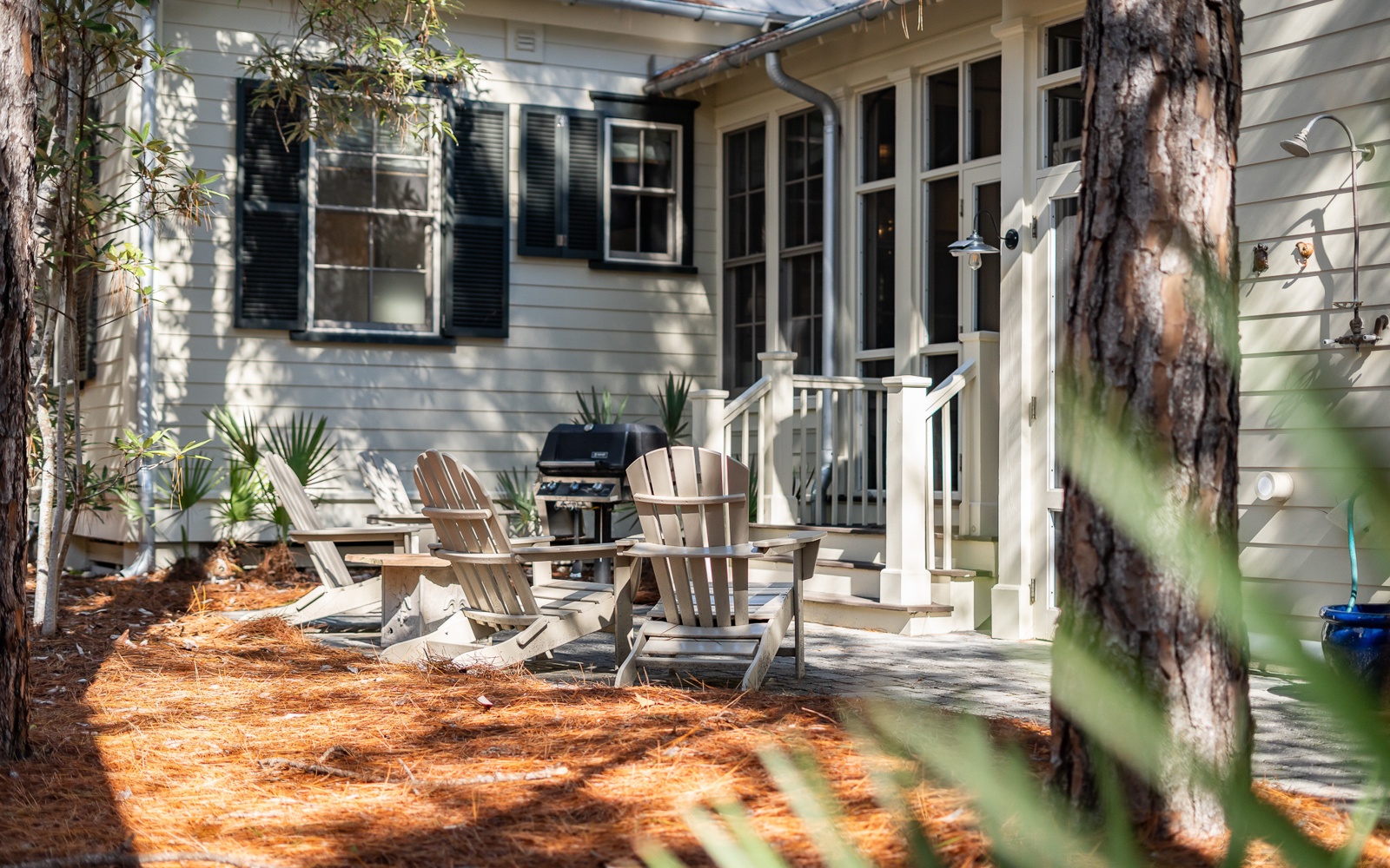 Relax in your private outdoor haven with comfortable seating and a BBQ grill ready for memorable meals under the trees.