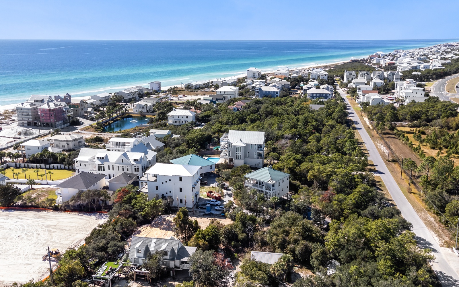 Stunning coastal community with pristine white sand beaches and crystal-clear turquoise waters stretching to the horizon.