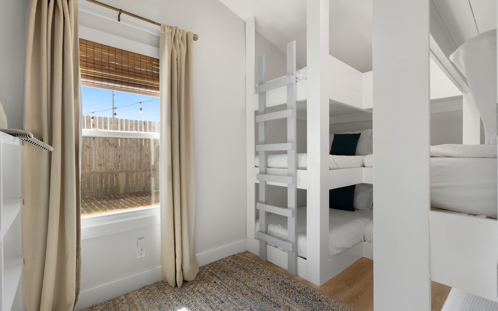 Rest comfortably in your private bunk room with custom-built beds and soft linens, where natural light streams through bamboo shades.