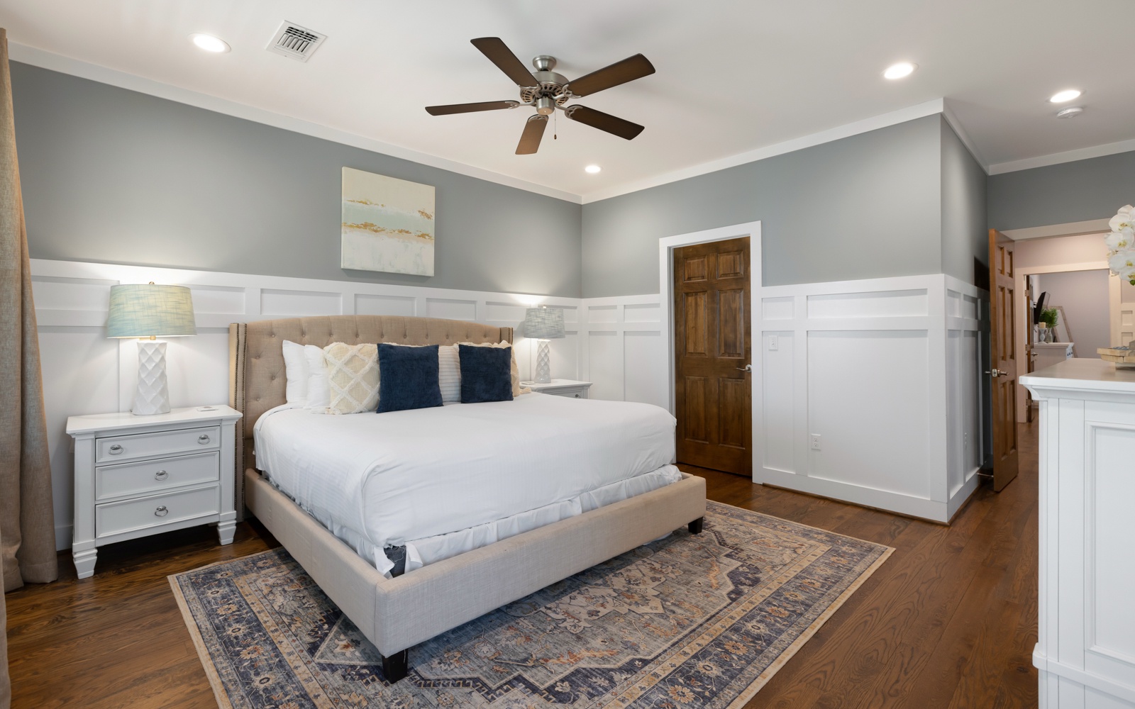 Rest peacefully in your elegant bedroom featuring crisp linens, calming colors, and a gentle ceiling fan for perfect comfort.