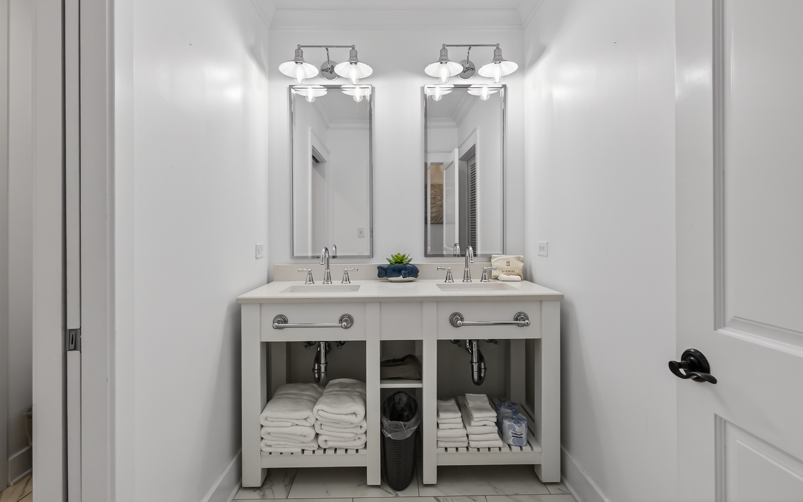 Step into your pristine bathroom featuring dual sinks and elegant mirrors, where fresh towels await your arrival.