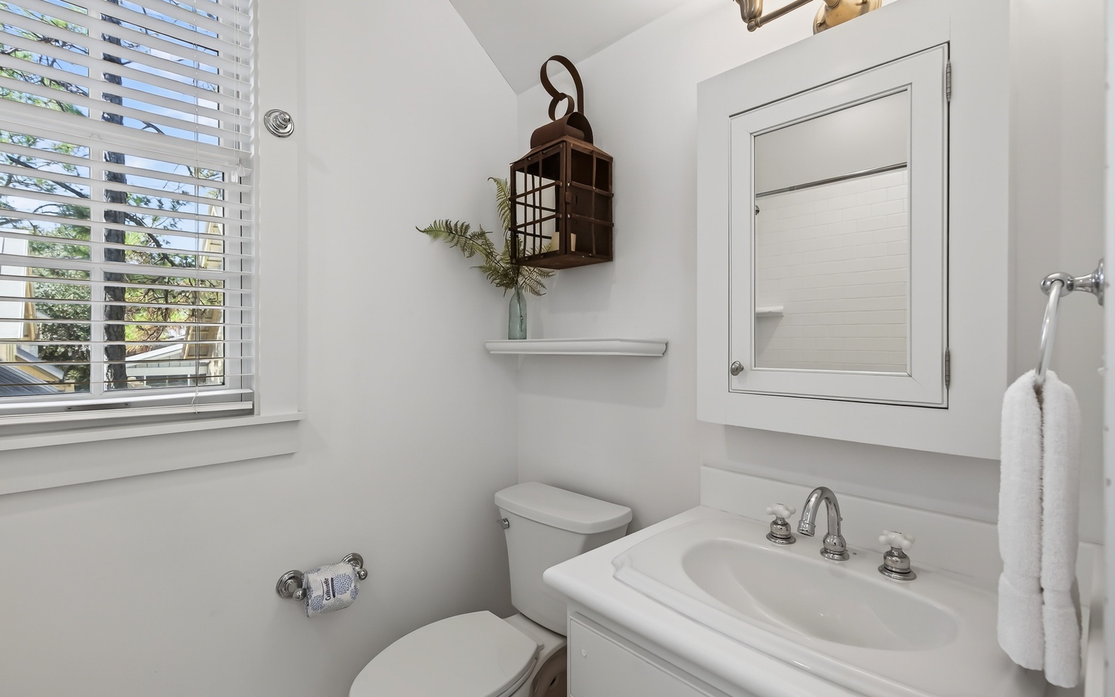 Freshen up in your bright, clean bathroom with thoughtful touches and natural light streaming through plantation shutters.