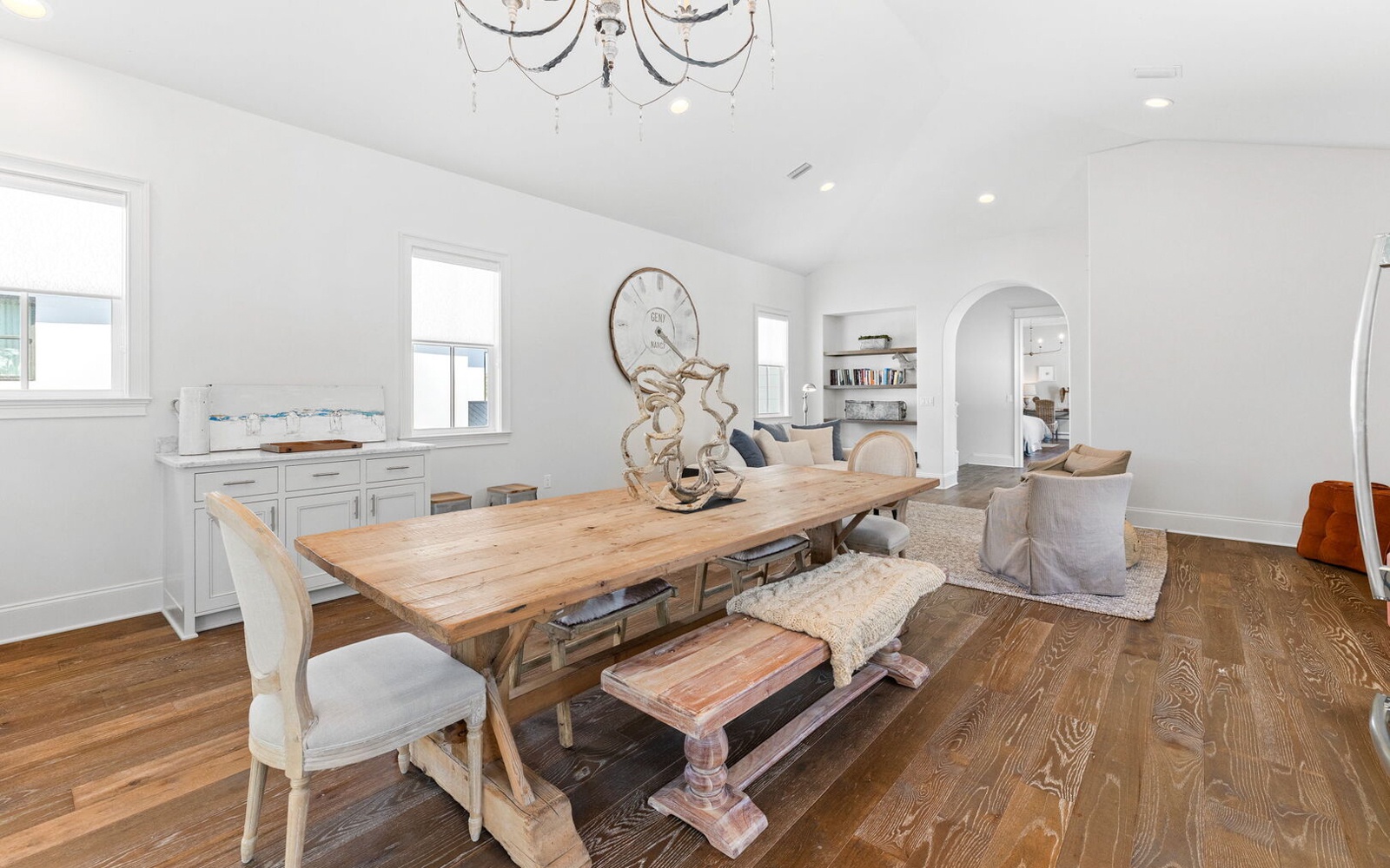 Gather around your rustic farmhouse table where warm wood meets elegant crystal lighting, perfect for memorable meals and conversations.