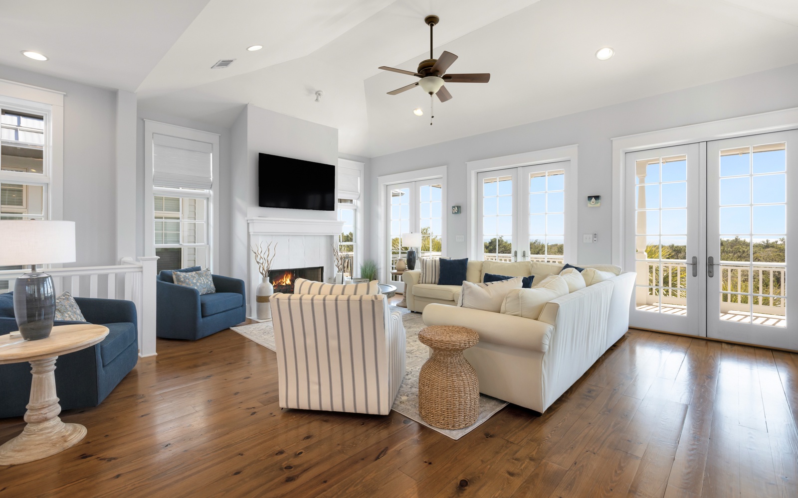 Relax in your spacious living room with cozy fireplace, comfortable seating, and stunning balcony views through floor-to-ceiling windows.