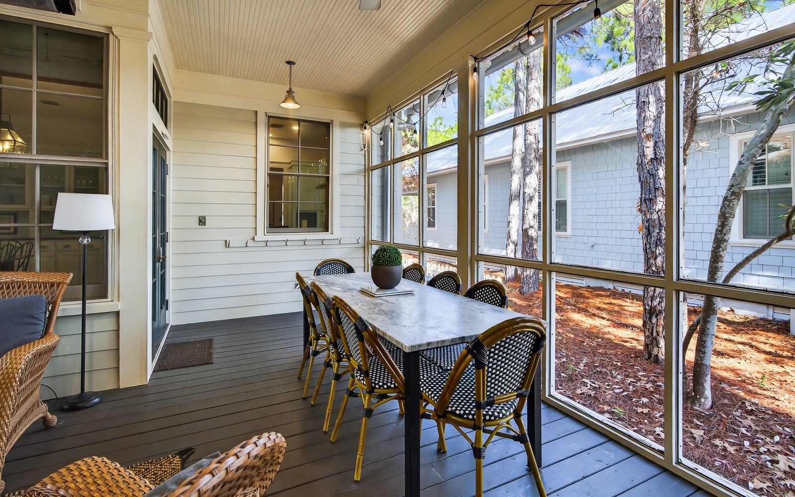 Enjoy peaceful meals in your screened-in porch, where natural light filters through tall windows and comfortable seating awaits your morning coffee.