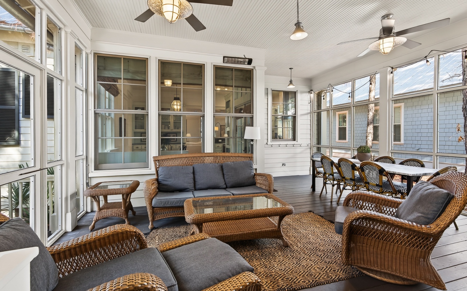 Relax in your screened porch with wicker seating and dining table, perfect for morning coffee or evening meals while staying cool.