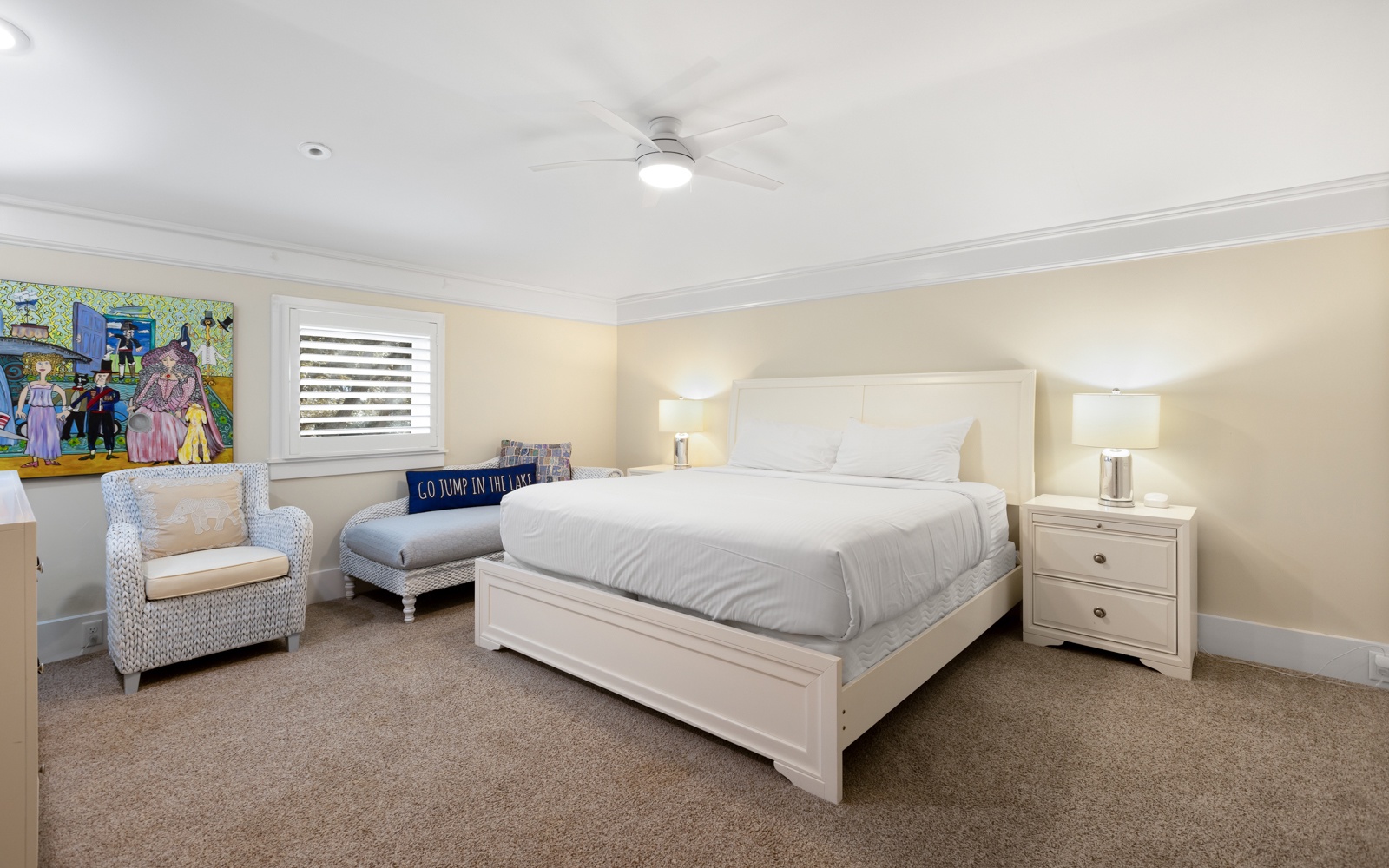Sink into your cozy bedroom's plush white bedding and enjoy the ceiling fan's gentle breeze after exploring the colorful local art adorning the walls.