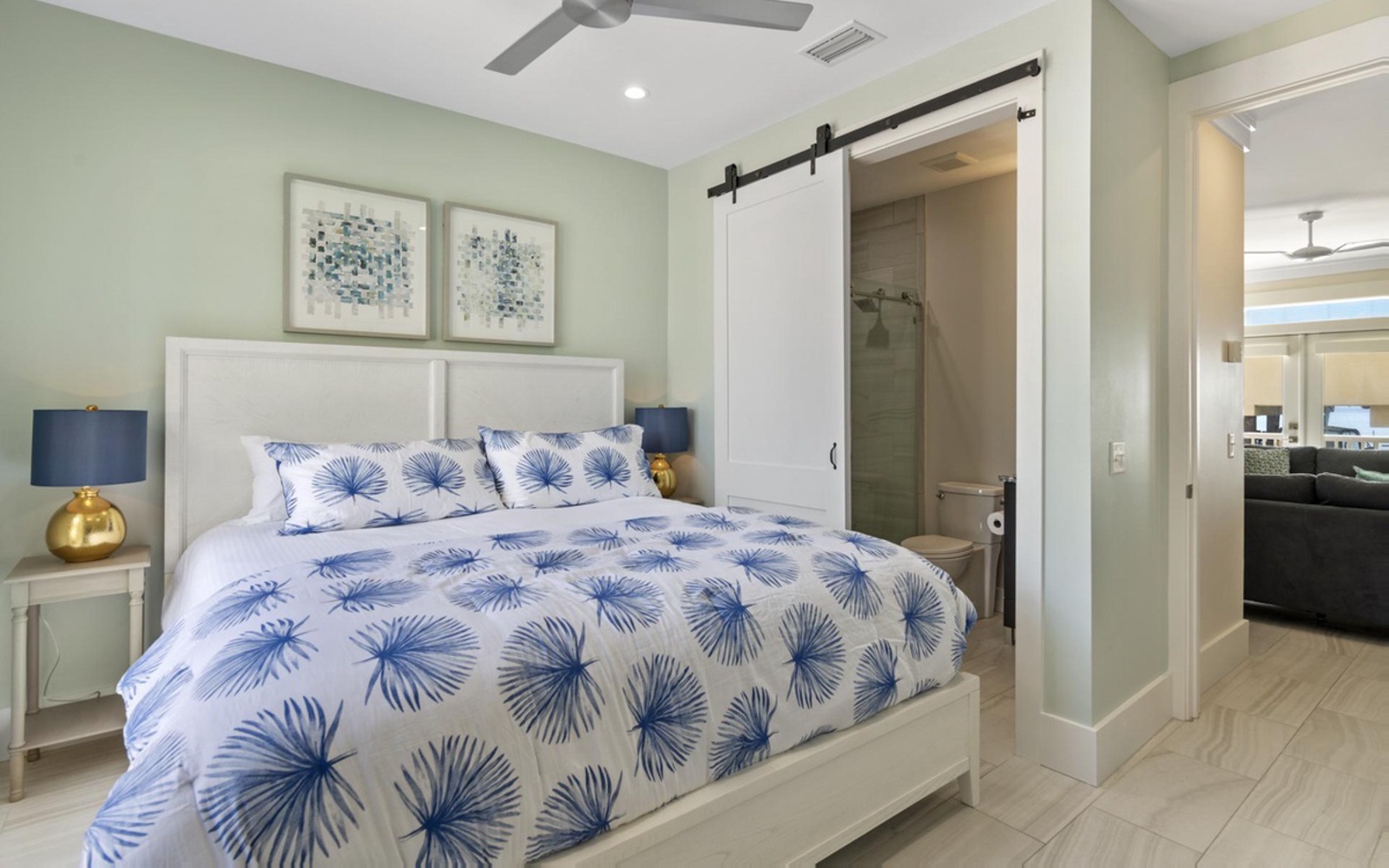 Your serene bedroom features tropical-inspired bedding and a private ensuite with stylish barn door for ultimate relaxation.