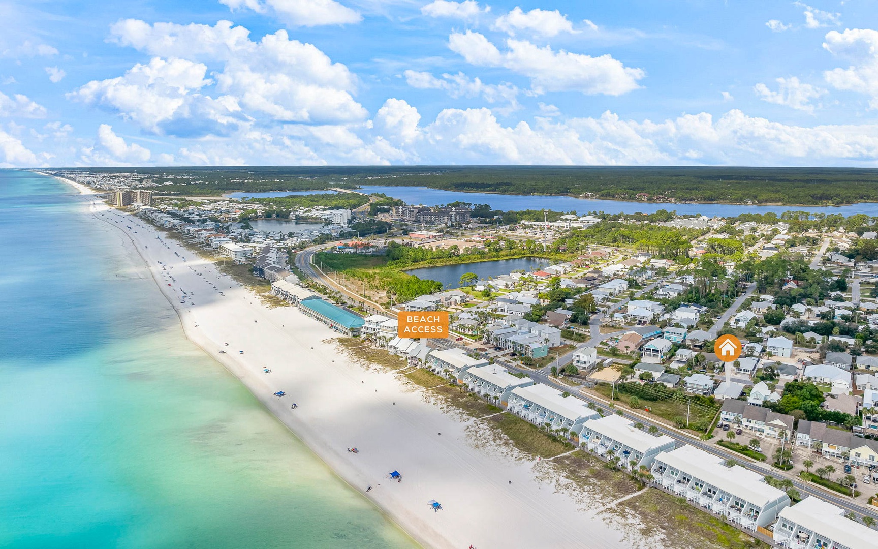 Aerial view of beachfront vacation rental area with white sand beach and turquoise waters.
