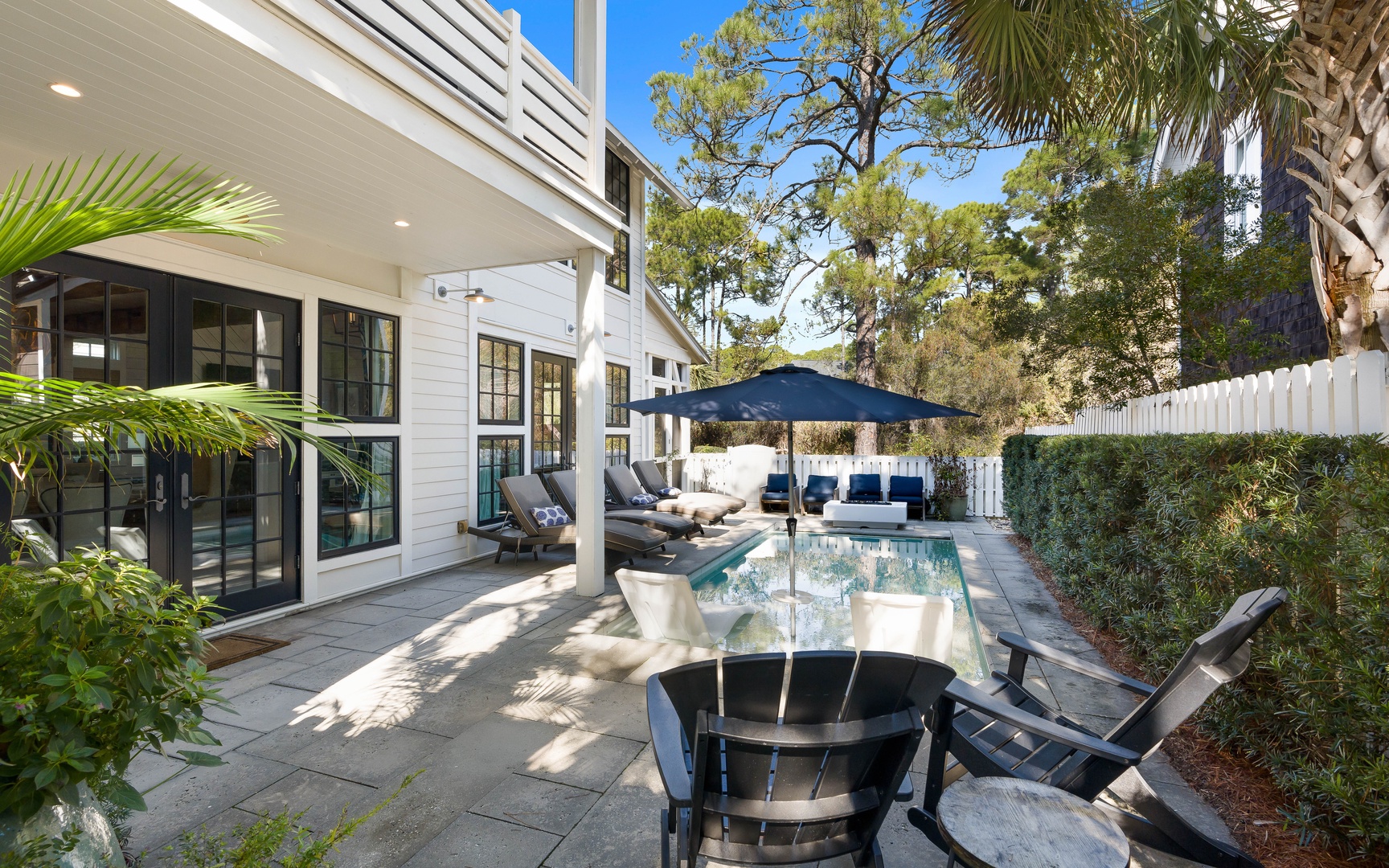 Unwind in your private backyard paradise with a sparkling pool, shaded dining, and lush tropical landscaping surrounding your modern retreat.