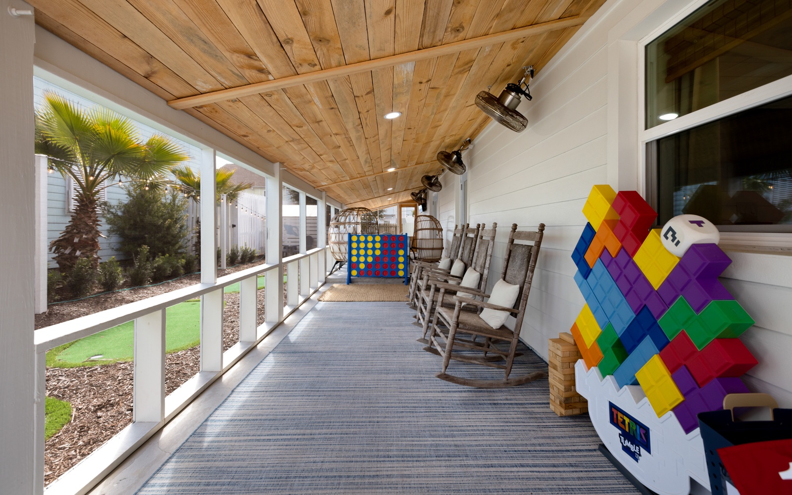 Settle into wooden rockers on your covered porch, where oversized games and warm lighting create perfect evenings for family fun.