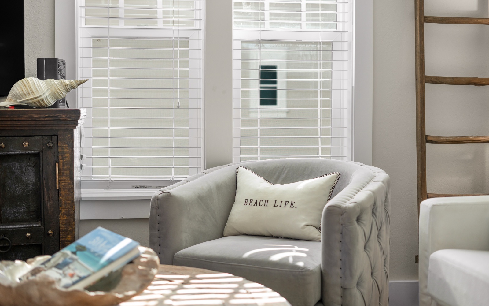 Sink into this plush armchair with your morning coffee as gentle sunlight filters through plantation shutters, creating the perfect reading nook.