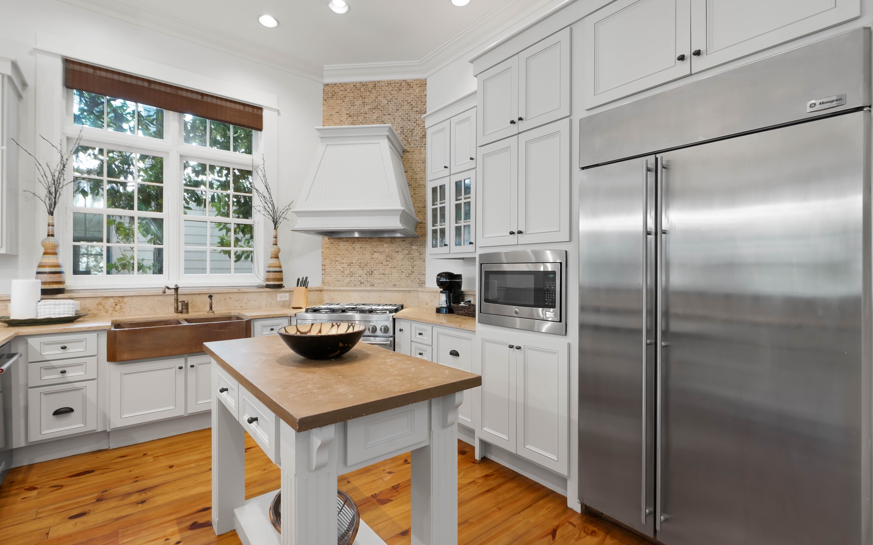 Your gourmet kitchen awaits with professional-grade appliances, butcher block island, and abundant natural light filtering through garden windows.