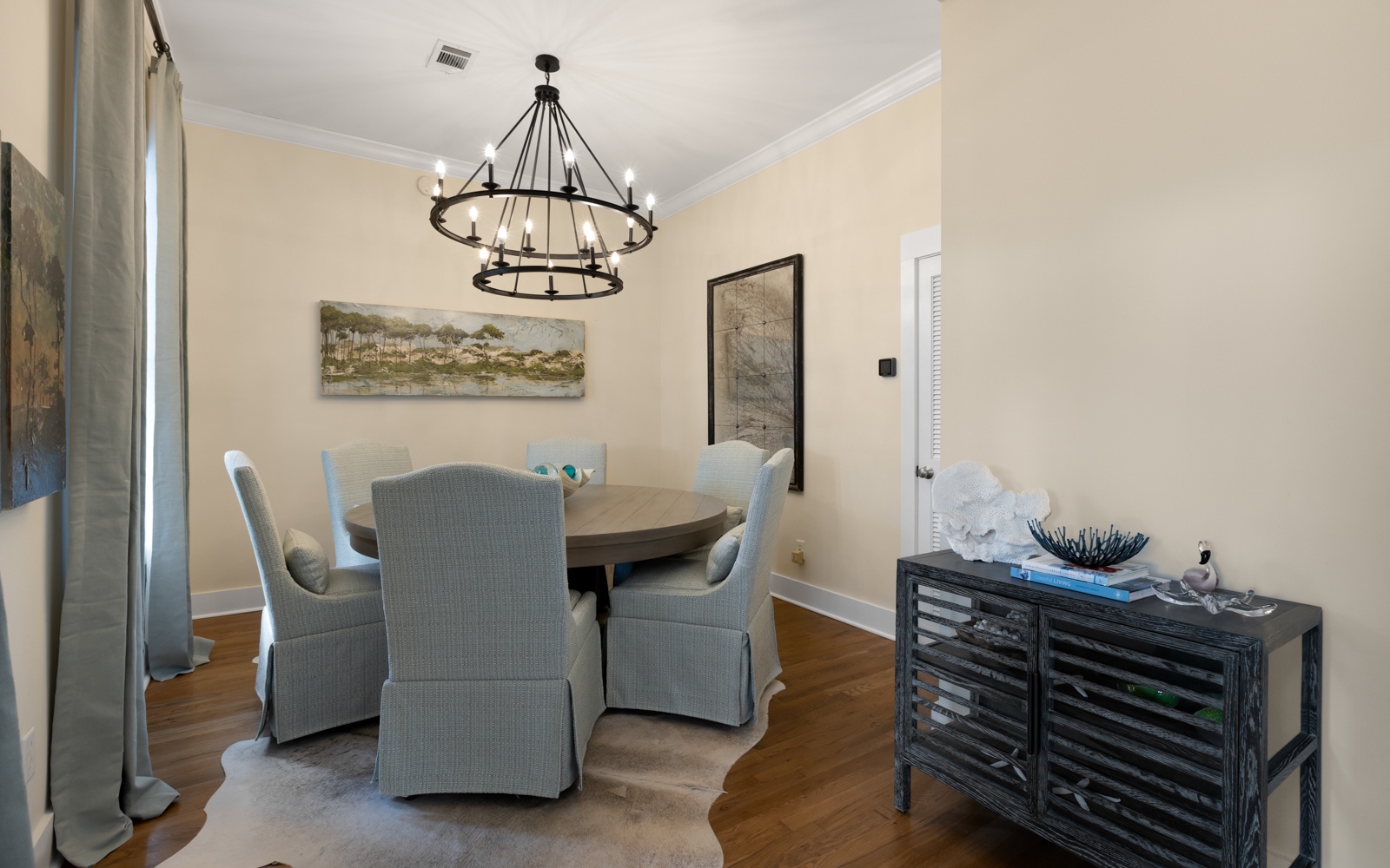 Gather around your elegant dining table beneath the stunning chandelier for memorable meals together.
