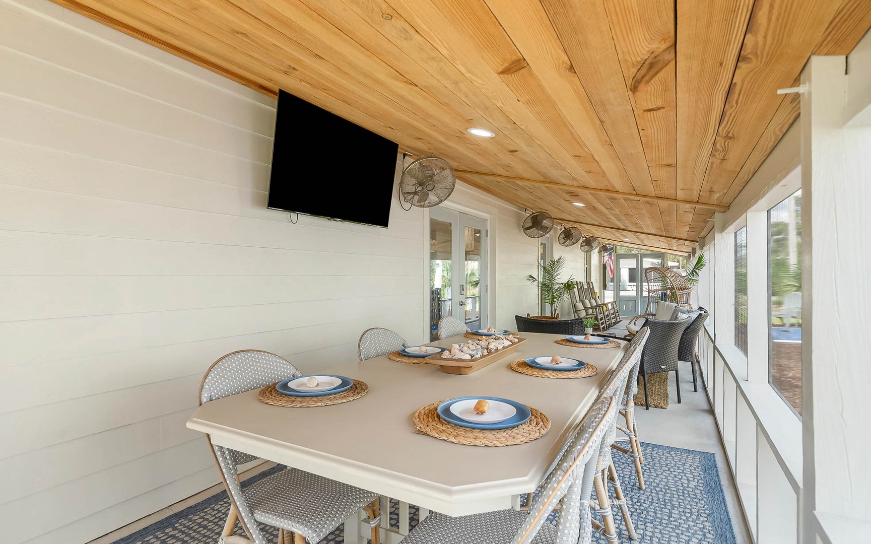 Your covered patio offers the perfect dining haven with warm wood beams overhead, comfortable seating, and entertainment at your fingertips.