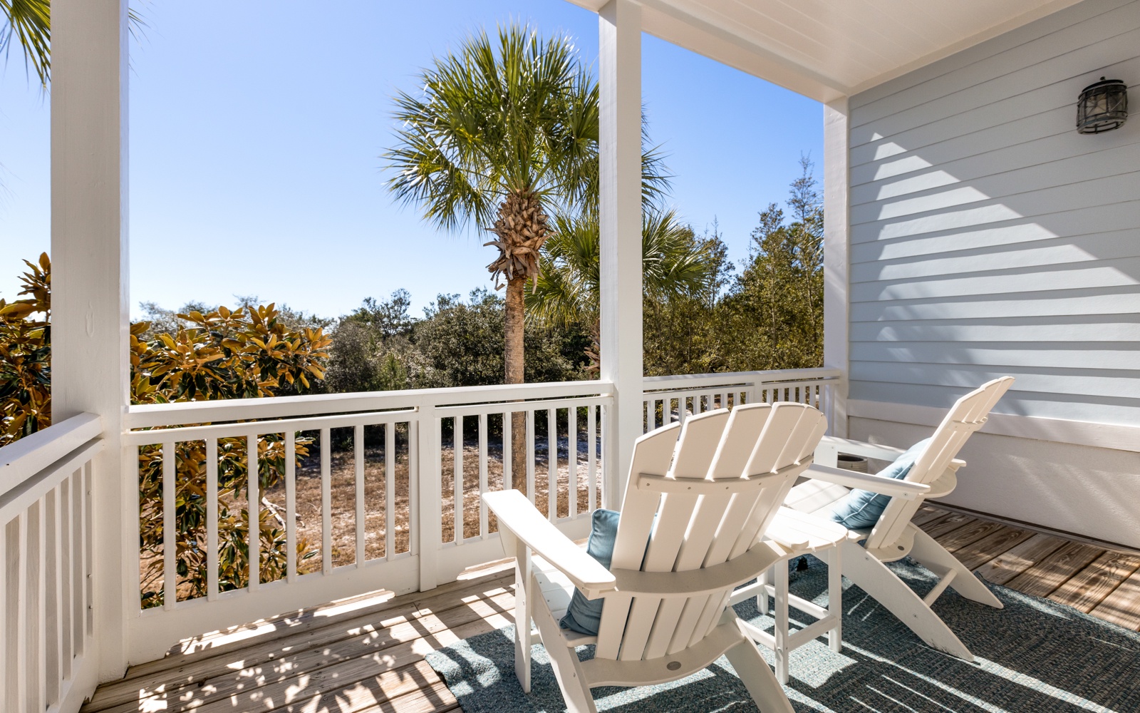 Relax in your private balcony chairs while enjoying tropical palm views and gentle morning light filtering through the covered porch.