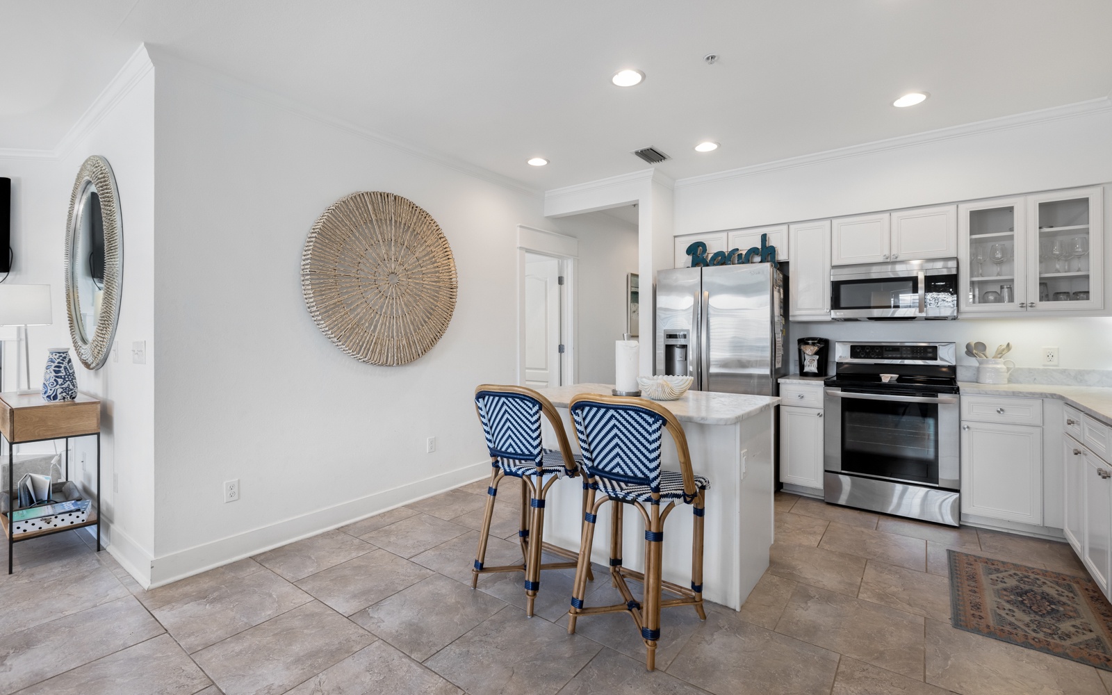 Your bright coastal kitchen awaits with stainless steel appliances, bar seating, and cheerful nautical touches for memorable meal prep.