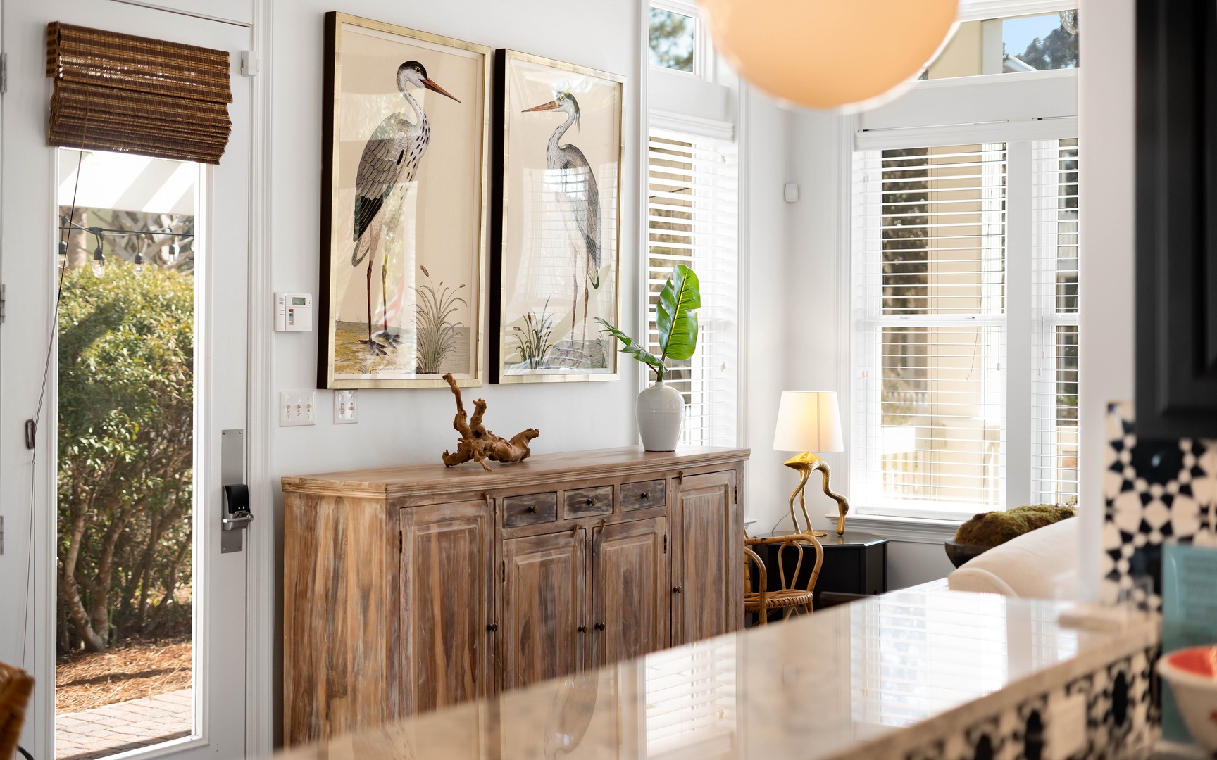 Relax at your elegant dining table while natural light streams through windows, creating the perfect spot for morning coffee or evening meals.