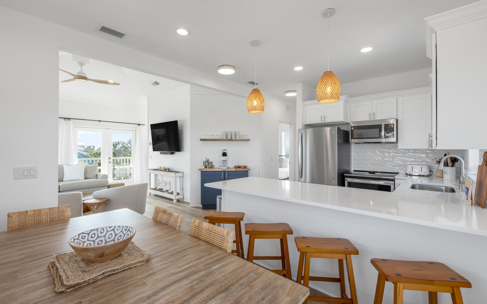 Gather around your spacious kitchen island with sleek bar seating, where coastal pendant lights create perfect ambiance for morning coffee or evening conversations.