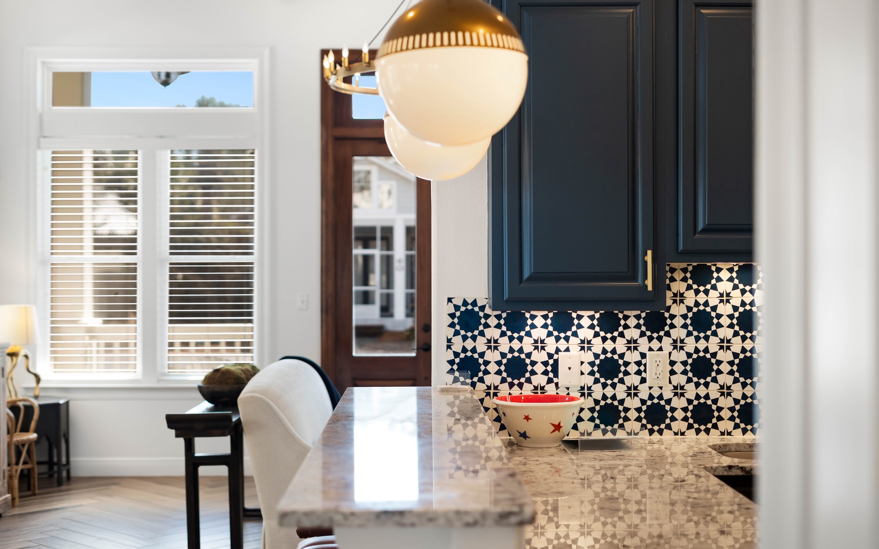 Your kitchen gleams with marble counters and striking navy cabinets, while patterned tiles add artistic flair to your culinary space.