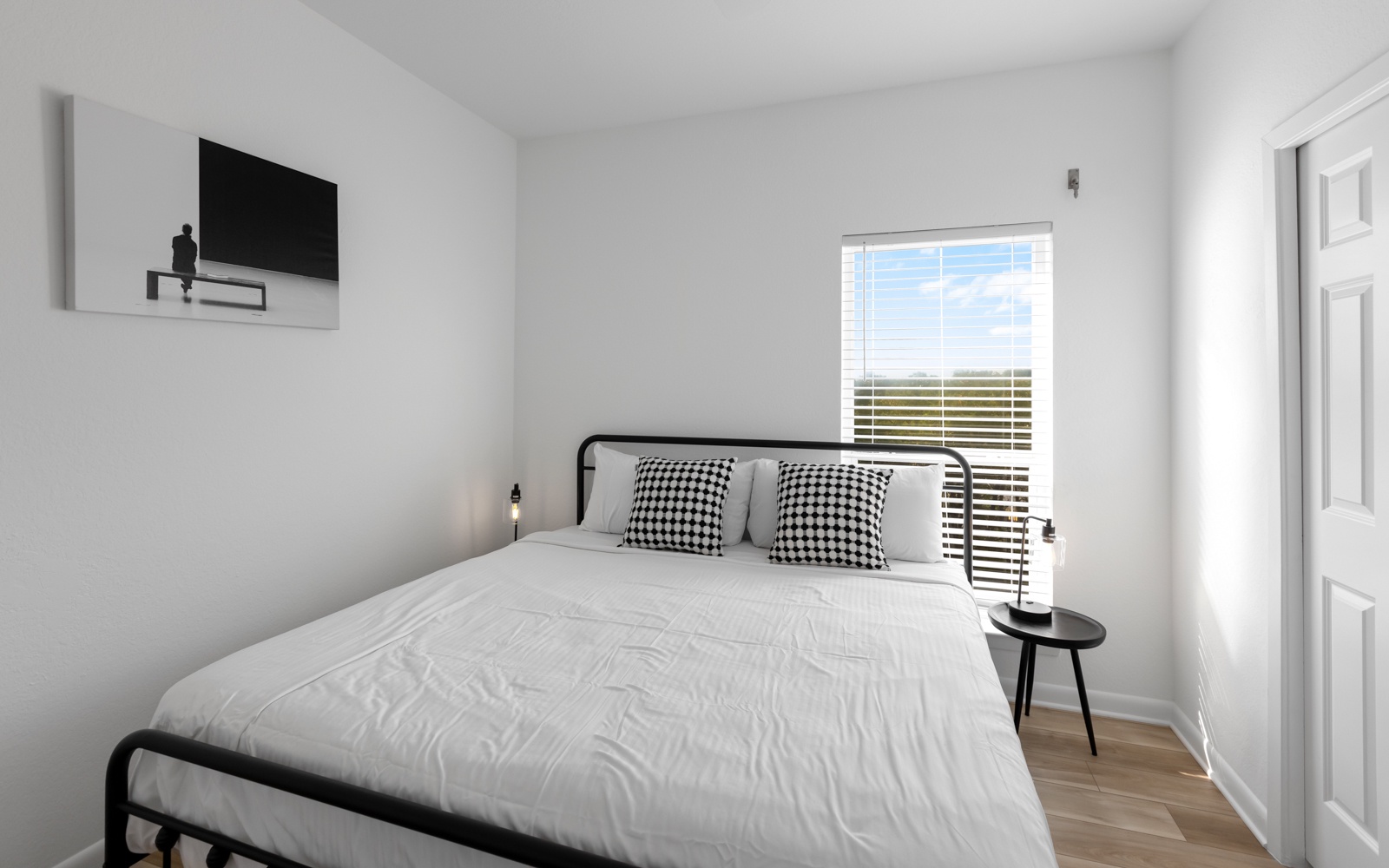 Wake up refreshed in your bright, modern bedroom featuring crisp linens and peaceful views through the window.