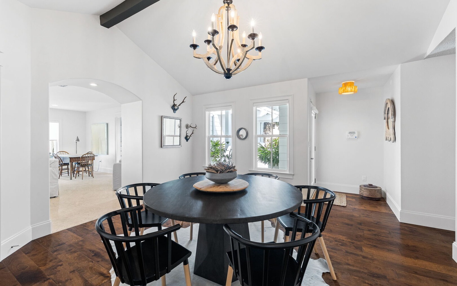 Share memorable meals at your elegant round dining table, where rustic beams and warm chandelier light create the perfect ambiance for conversations.