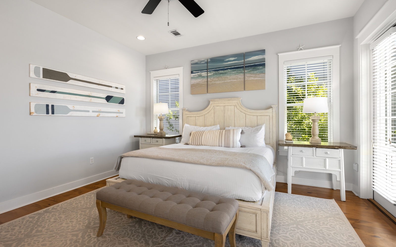 Drift into peaceful sleep in this serene bedroom with coastal artwork, plush bedding, and gentle natural light filtering through your windows.