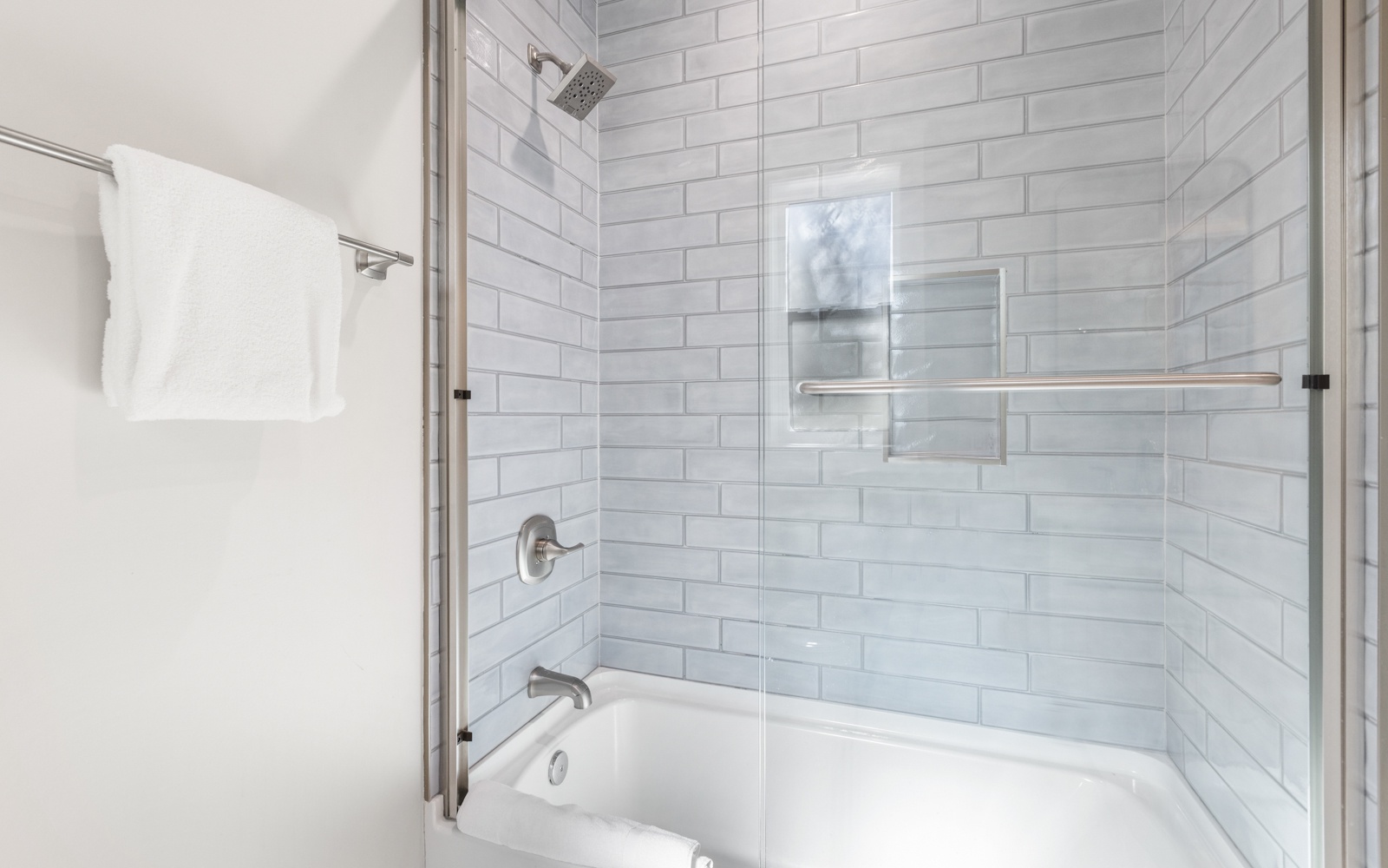 Step into your spa-like retreat featuring elegant subway tiles, rainfall shower, and deep soaking tub for ultimate relaxation.