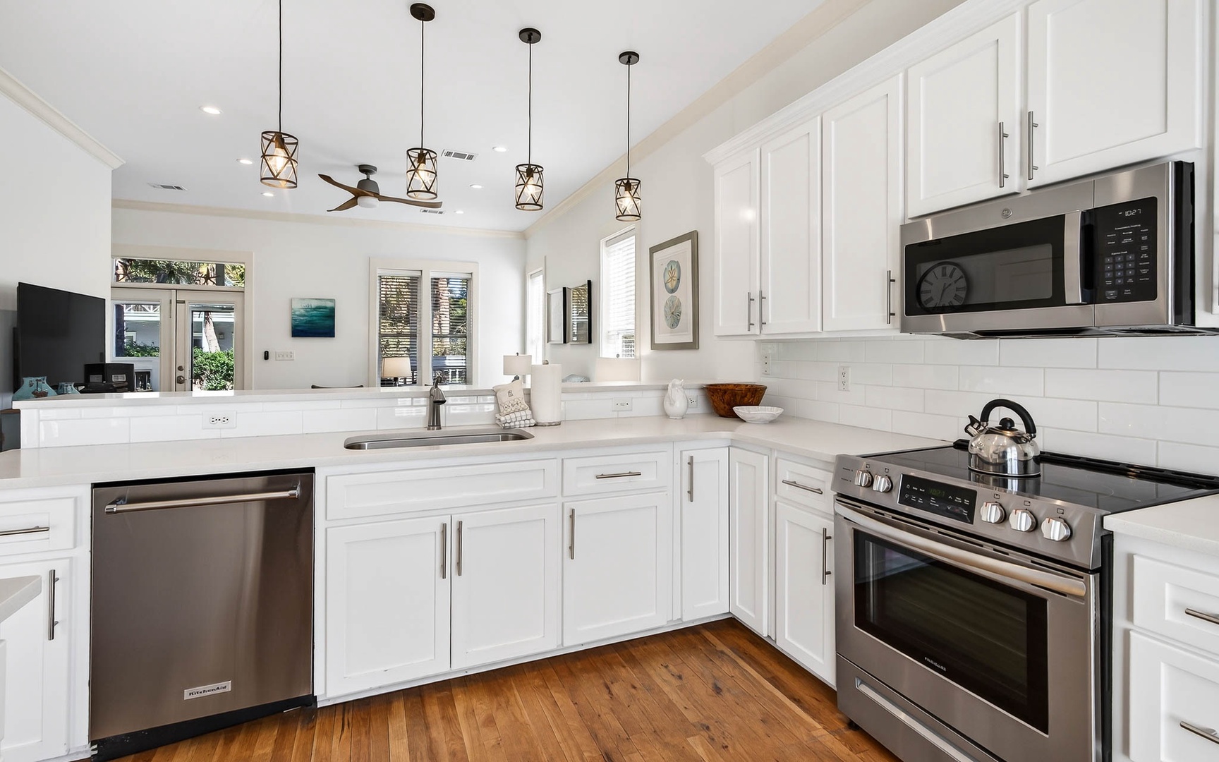 Cook with joy in your bright, modern kitchen featuring pristine white cabinets, gleaming stainless appliances, and stylish pendant lighting overhead.