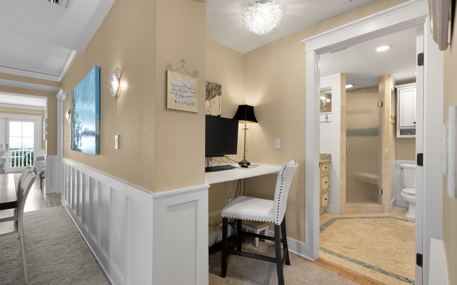 Your private workspace awaits with elegant touches and a stunning chandelier overhead, while the nearby bathroom provides luxury convenience.