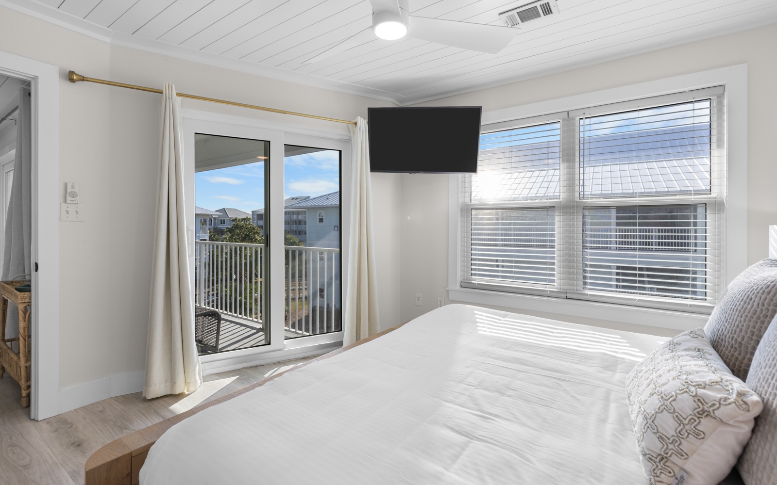 Wake up to natural light streaming through your private balcony doors in this serene bedroom retreat with coastal views.
