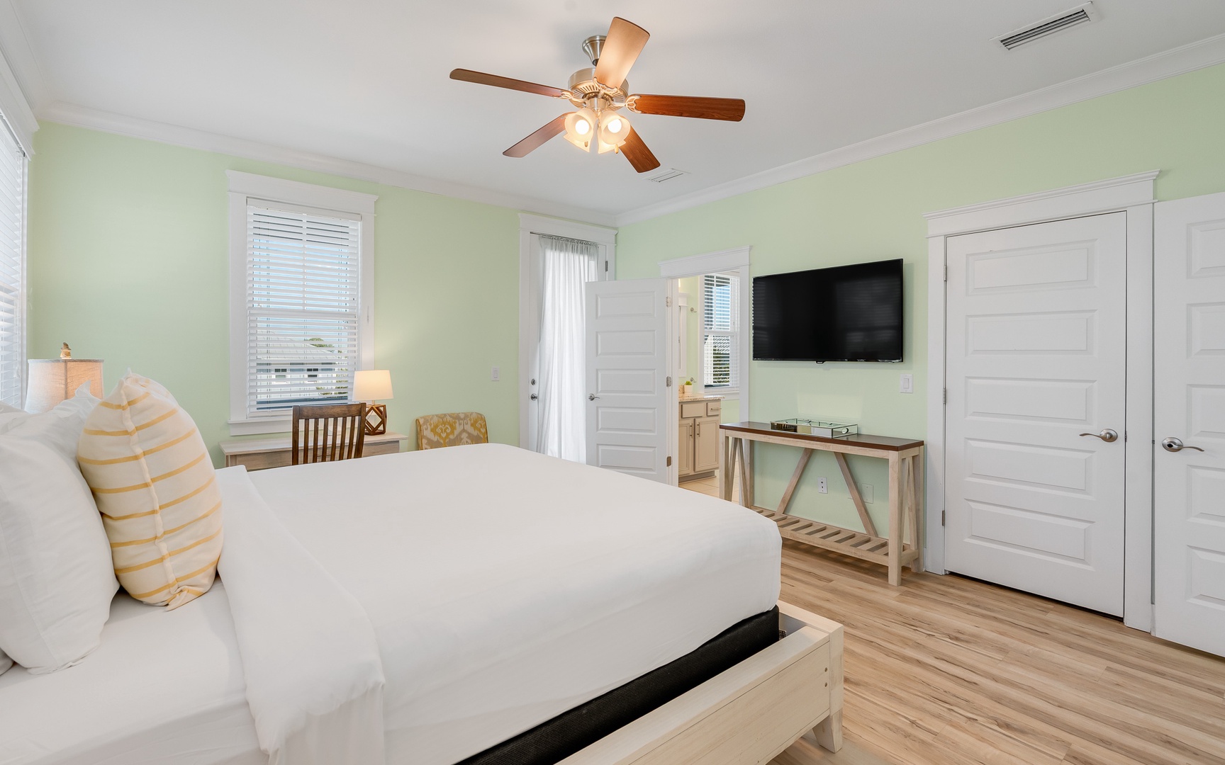 Unwind in your serene bedroom with soothing mint walls, crisp linens, and modern amenities for peaceful nights.