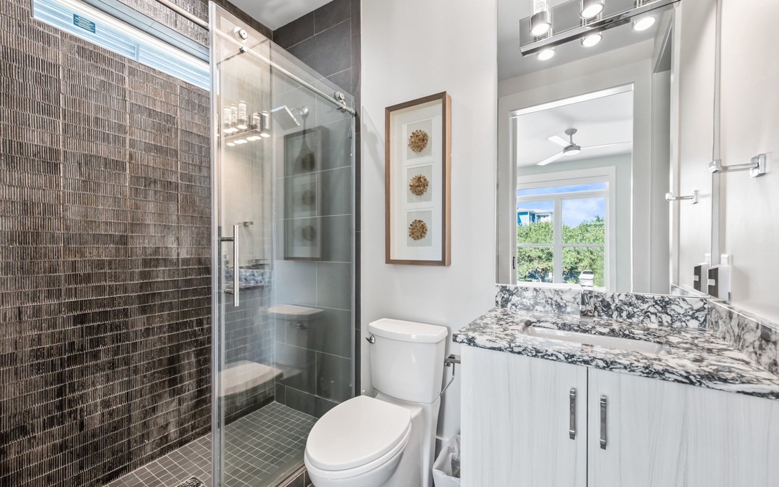 Your elegant bathroom features a glass-enclosed shower, marble vanity, and modern finishes for a luxurious retreat.