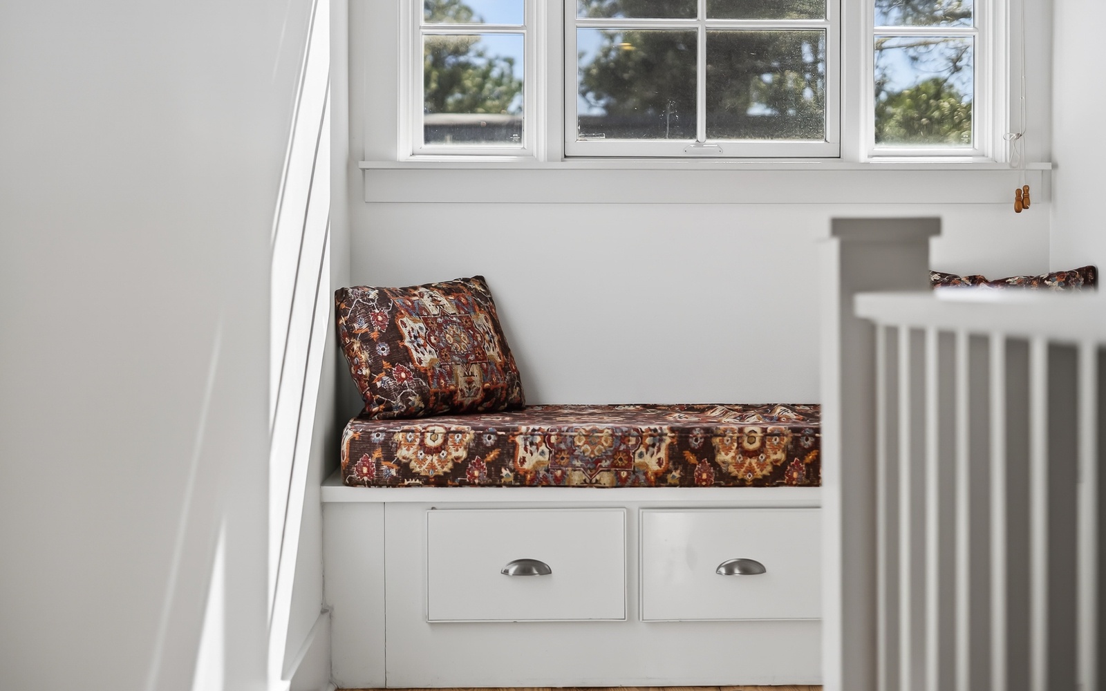 Cozy window seat with storage drawers where you can curl up with a book while natural light fills the space.