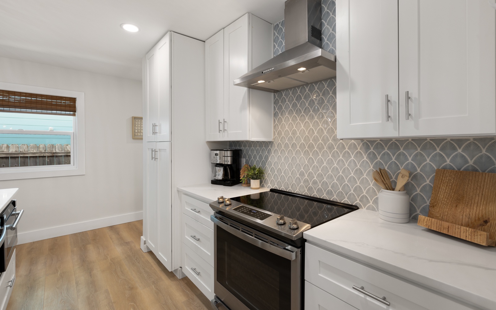 Step into your sleek modern kitchen featuring premium appliances, stunning geometric backsplash, and ample counter space for cooking memorable meals.