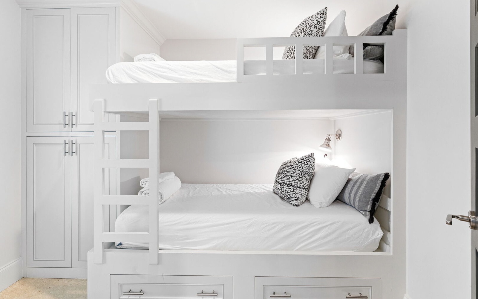 Your kids will love this bright white bunk bed setup with cozy reading lights and built-in storage for their treasures.