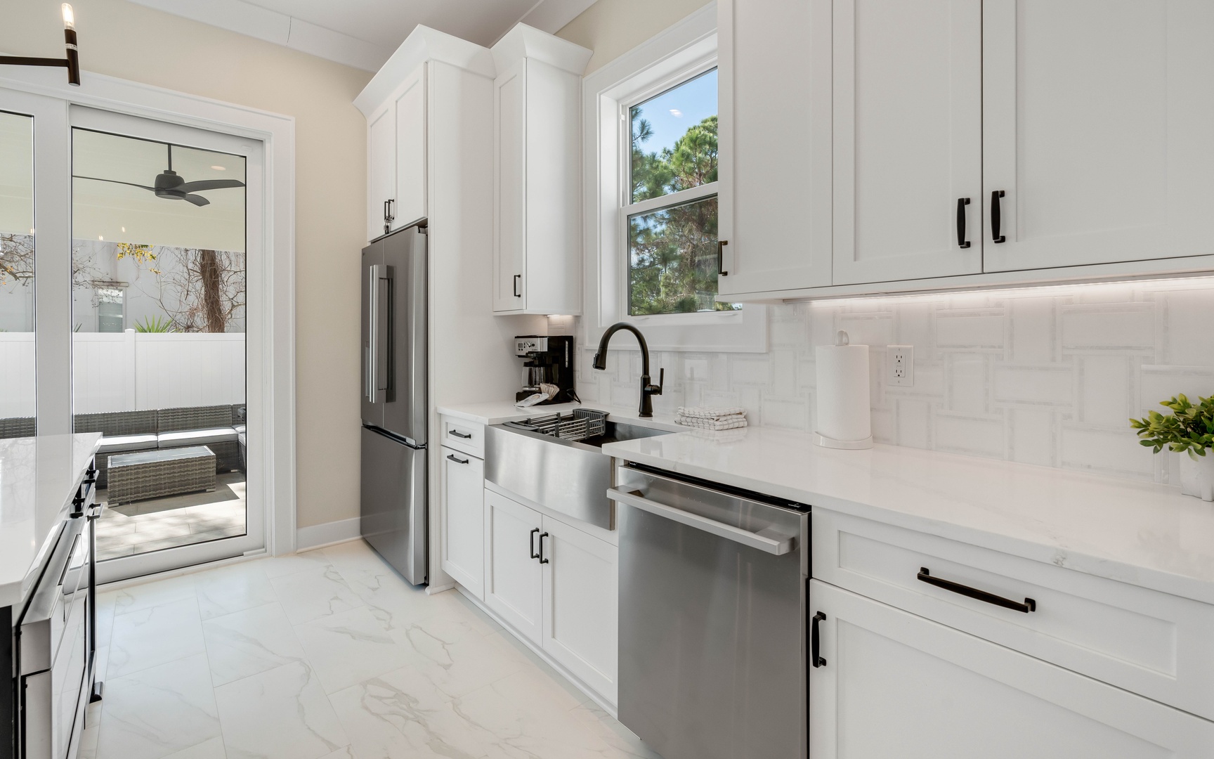 Your sleek modern kitchen features crisp white cabinetry, premium stainless steel appliances, and pristine countertops—perfect for preparing memorable meals during your stay.