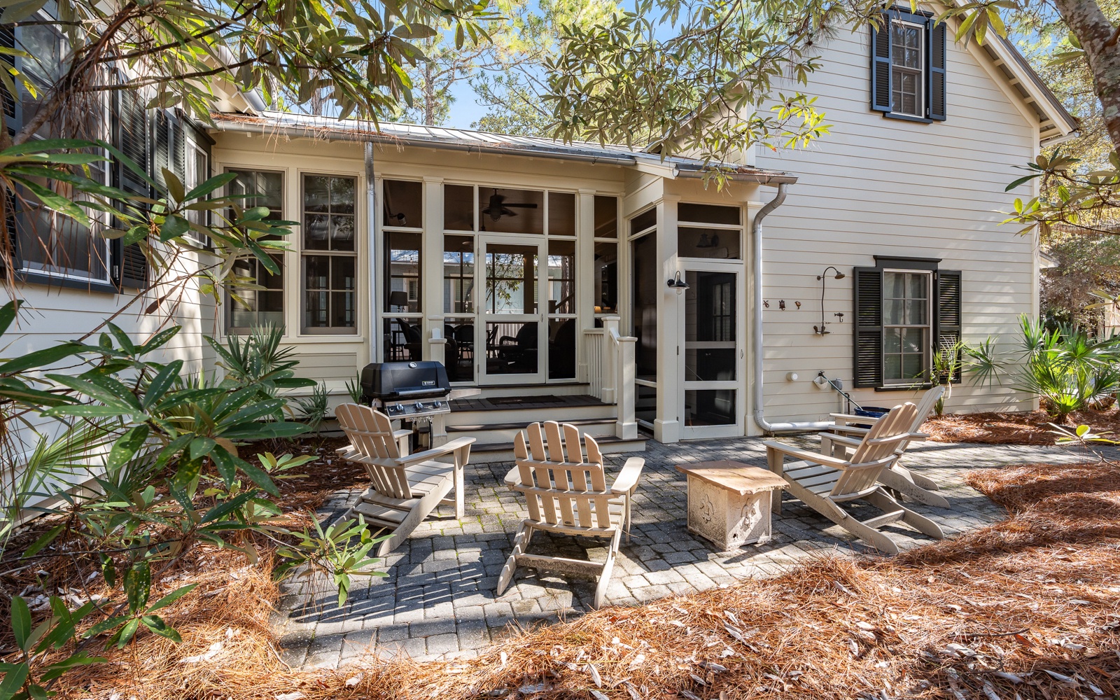 Relax in your private outdoor haven with cozy Adirondack chairs, BBQ grill, and screened porch perfect for morning coffee or evening gatherings.