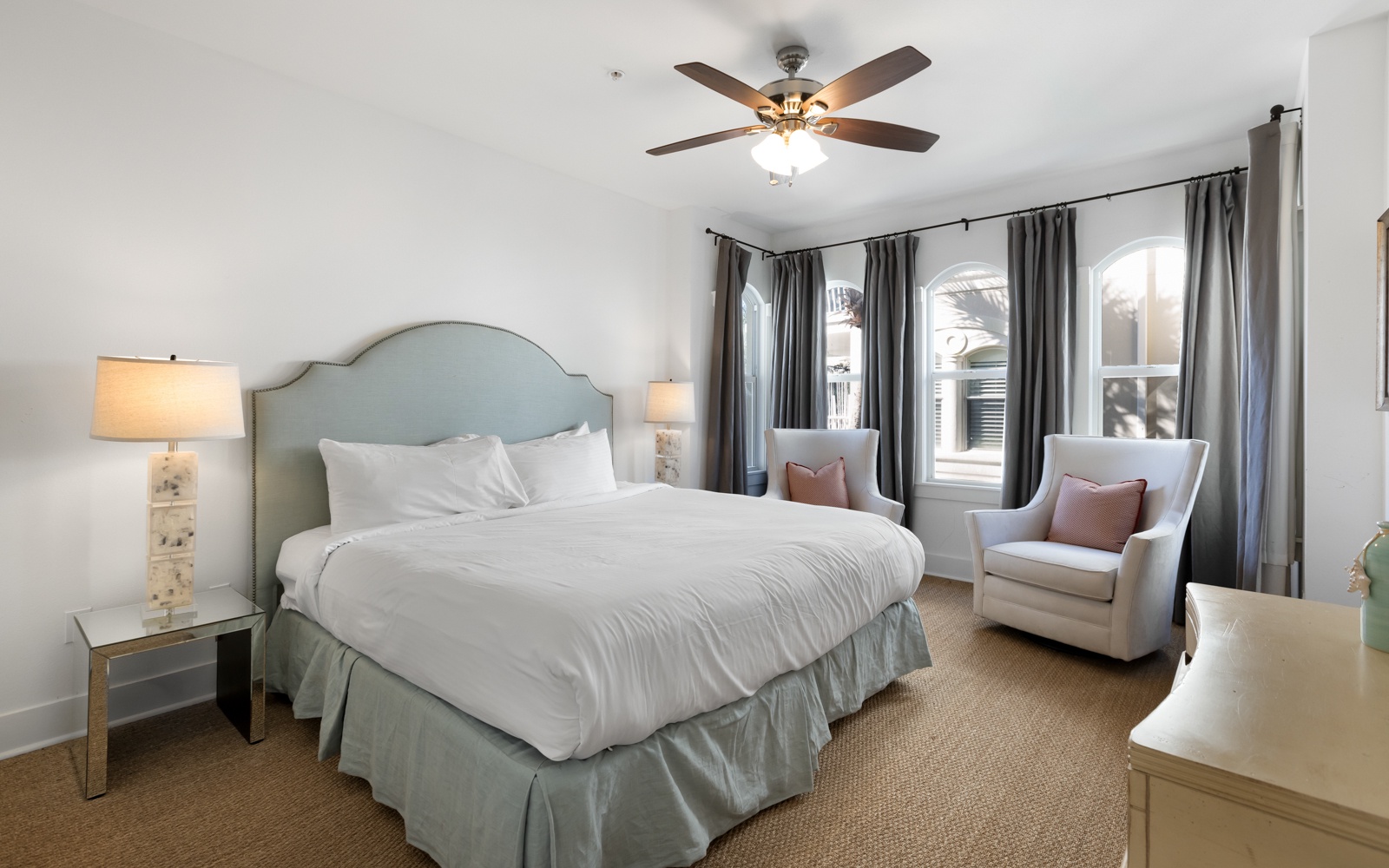 Sink into crisp white linens and unwind in your elegant reading chairs, where soft lighting creates the perfect sanctuary for rest.